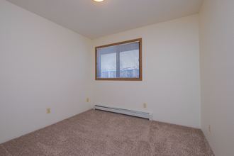 a bedroom with a window. Fargo, ND South Pointe Apartments