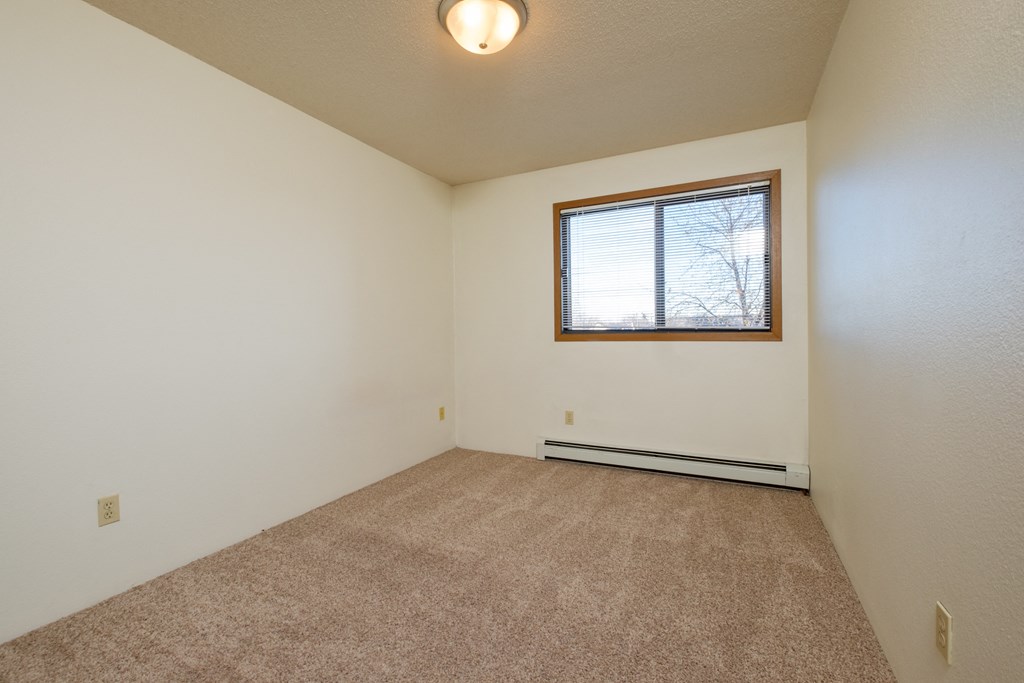 a bedroom with a window. Fargo, ND South Pointe Apartments