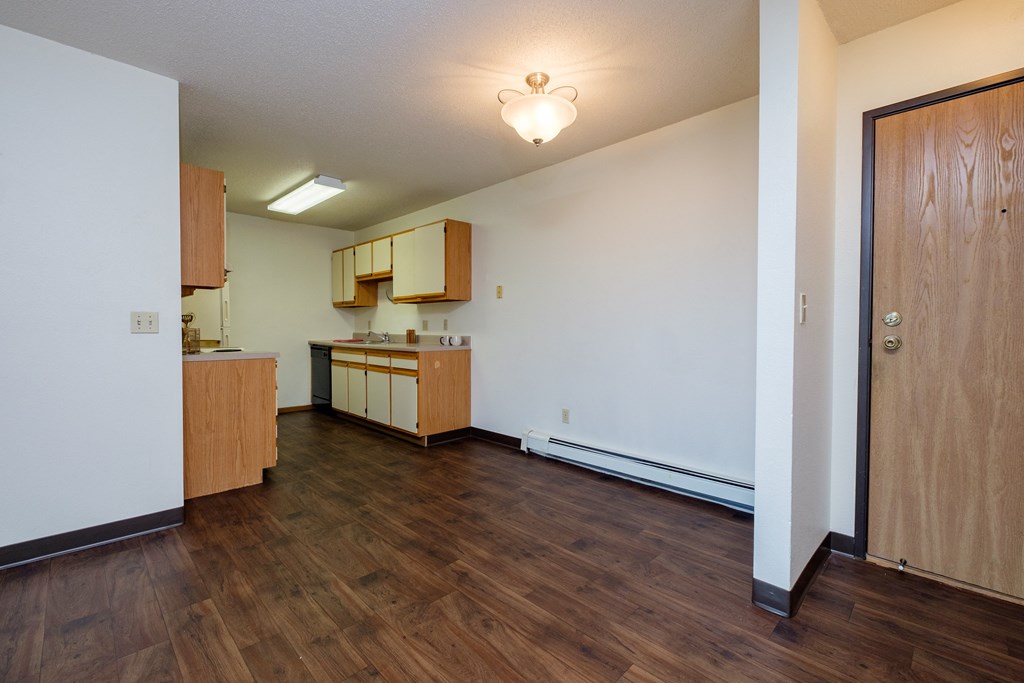 a dining room with a kitchen in the background. Fargo, ND South Pointe Apartments