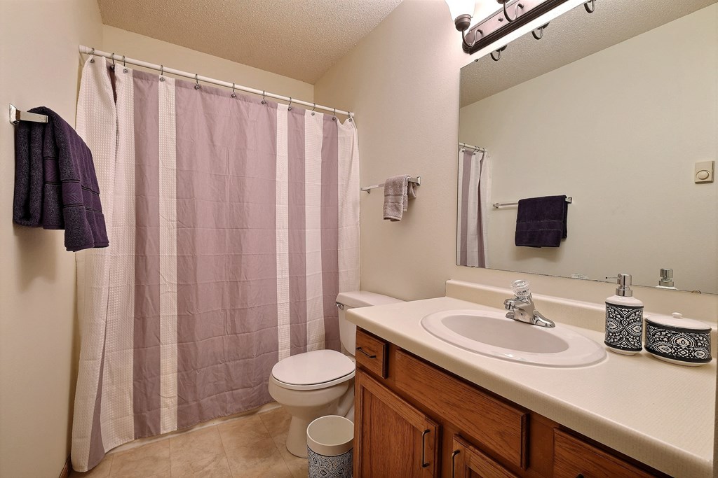 a bathroom with a sink and a toilet and a shower. Fargo, ND Southgate Apartments