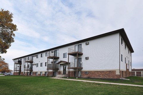 The exterior of a three level apartment building with a grass area out front. Fargo, ND Southgate Apartments