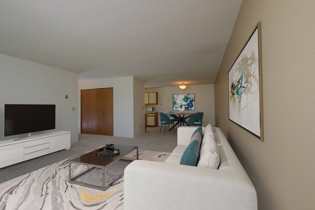 a living room with a couch and a coffee table. Fargo, ND South Pointe Apartments