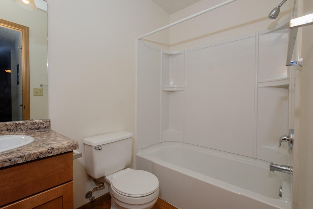 a bathroom with a sink and a toilet and a shower. Fargo, ND Southwind Apartments