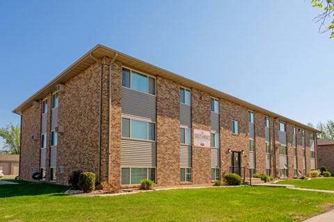 a three level apartment building with green grass out front. Fargo, ND Southwind Apartments