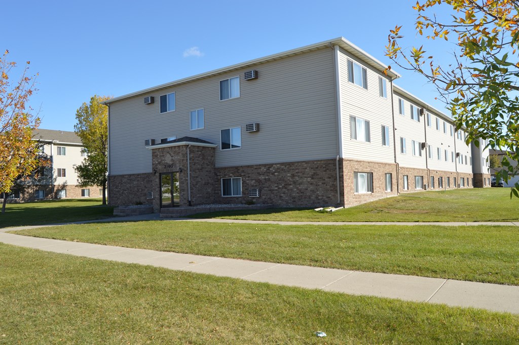 an apartment building with a sidewalk in front of it. Fargo, ND Sterling Park Apartments