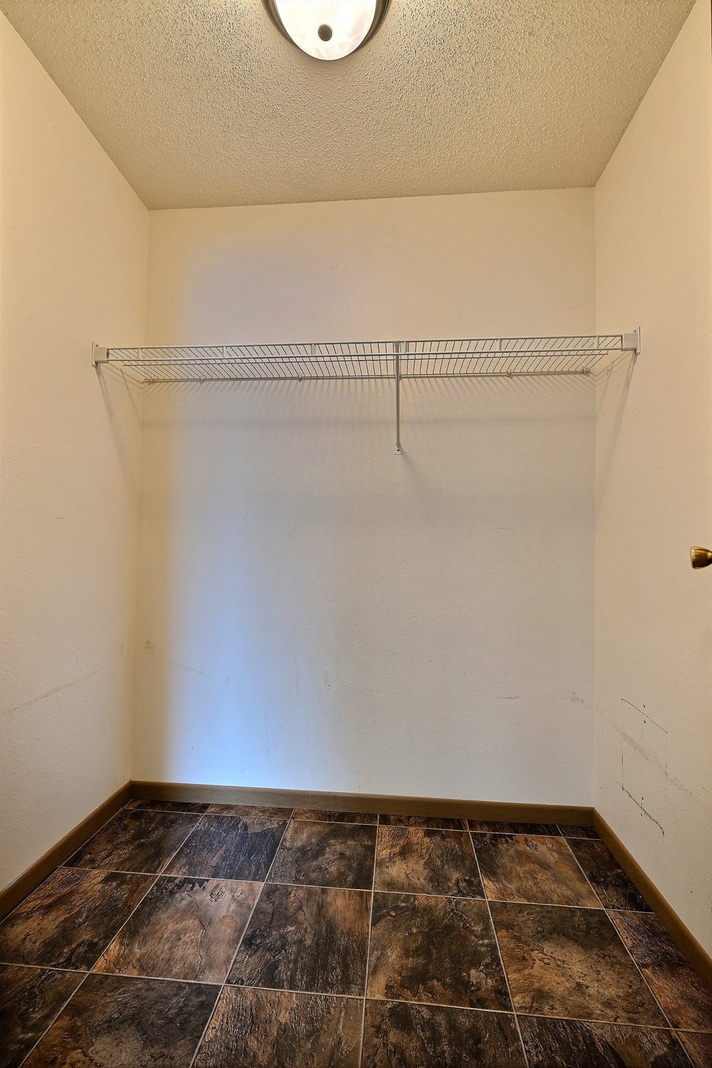 the closet of an empty room with a shelf on the wall. Fargo, ND Sterling Park Apartments