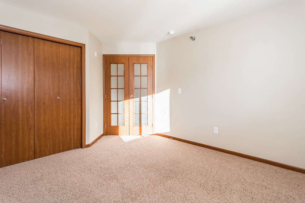 Grand Forks Sterling Pointe Apartments. A bedroom with French doors and a closet.