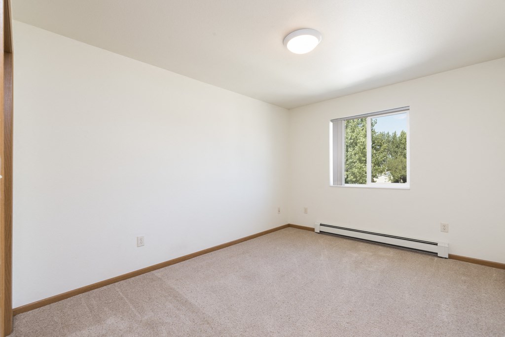 Empty room with carpet and a window at Sunset Ridge Apartments in Bismarck, 58503