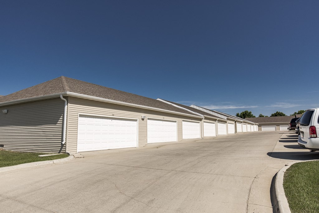 a row of garages with cars parked in front of them. Bismarck, ND Sunset Ridge Apartments