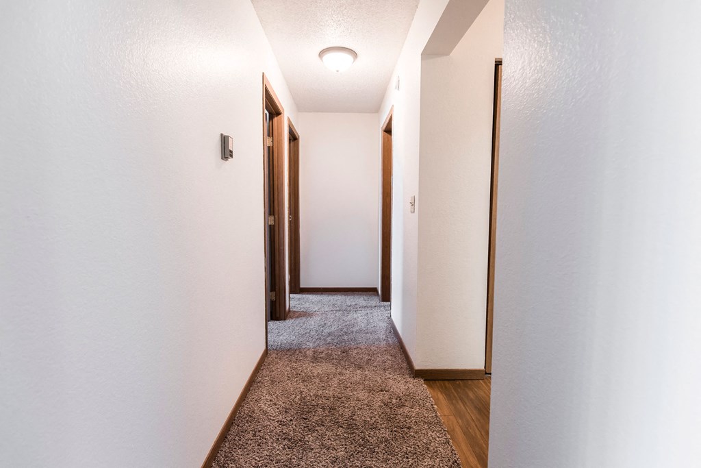 Grand Forks, ND Sunview apartments. a hallway with white walls and wooden floors