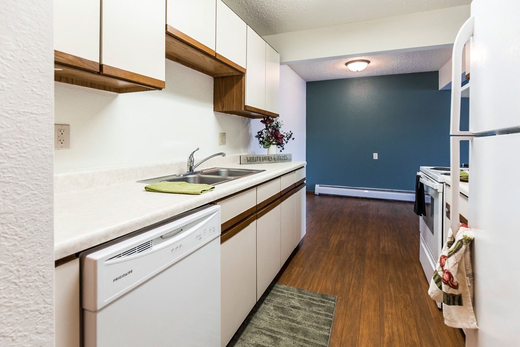 Grand Forks, ND Sunview apartments. a kitchen with white cabinets and a white dishwasher