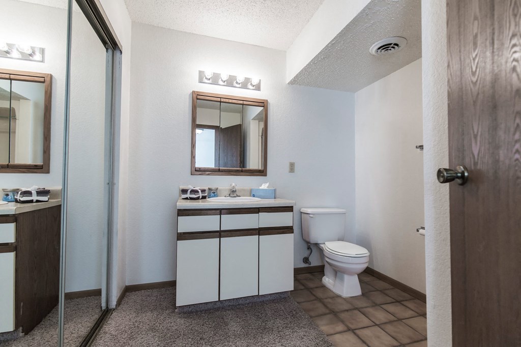 Grand Forks, ND Sunview apartments. a bathroom with a toilet sink mirror and shower