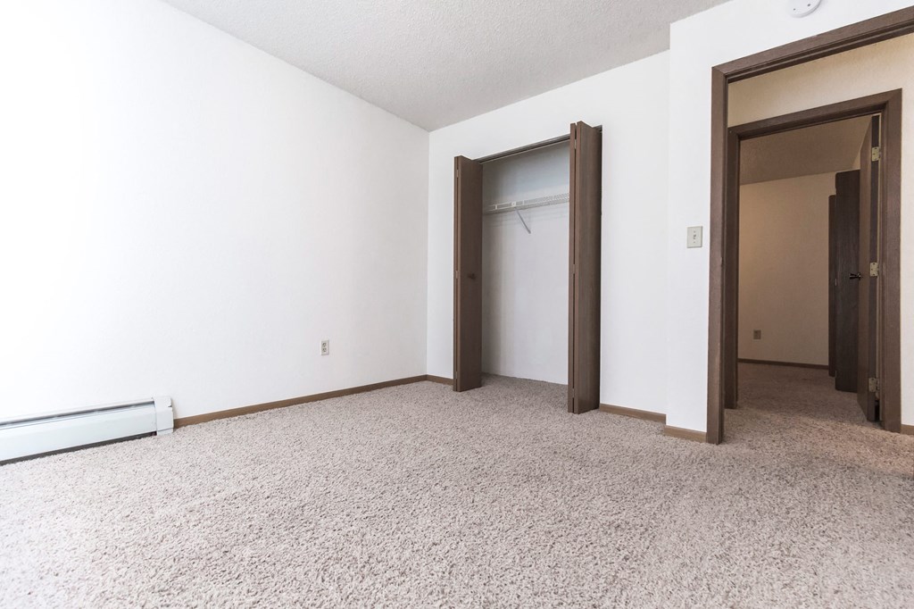 Grand Forks, ND Sunview apartments. a bedroom with white walls and a carpeted floor