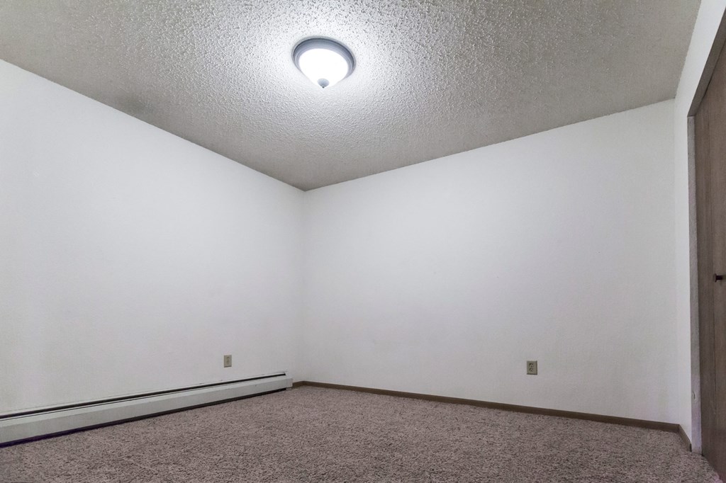 Grand Forks, ND Sunview apartments. a small empty room with white walls and carpet