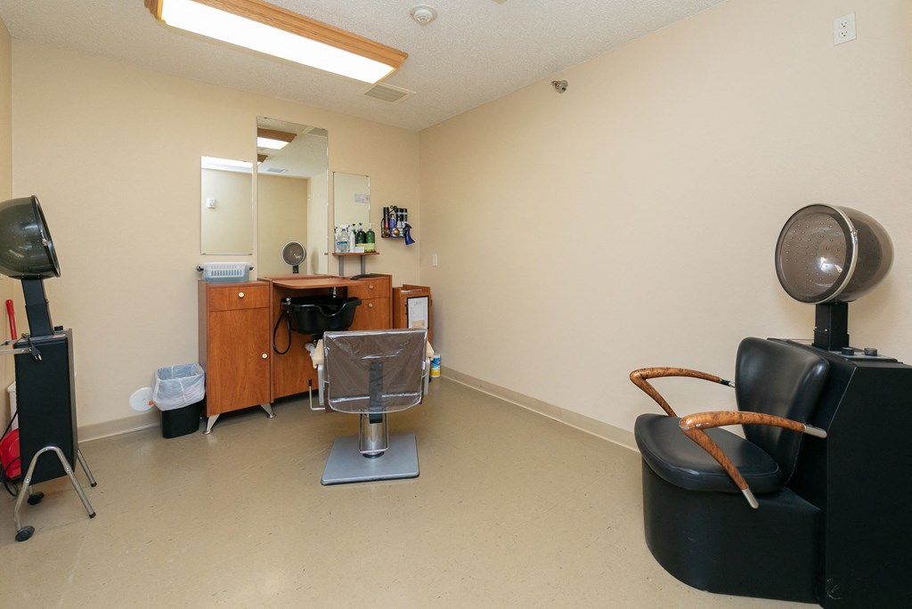 a salon with a chair and desk with a mirror. Fargo, ND Sunrise North