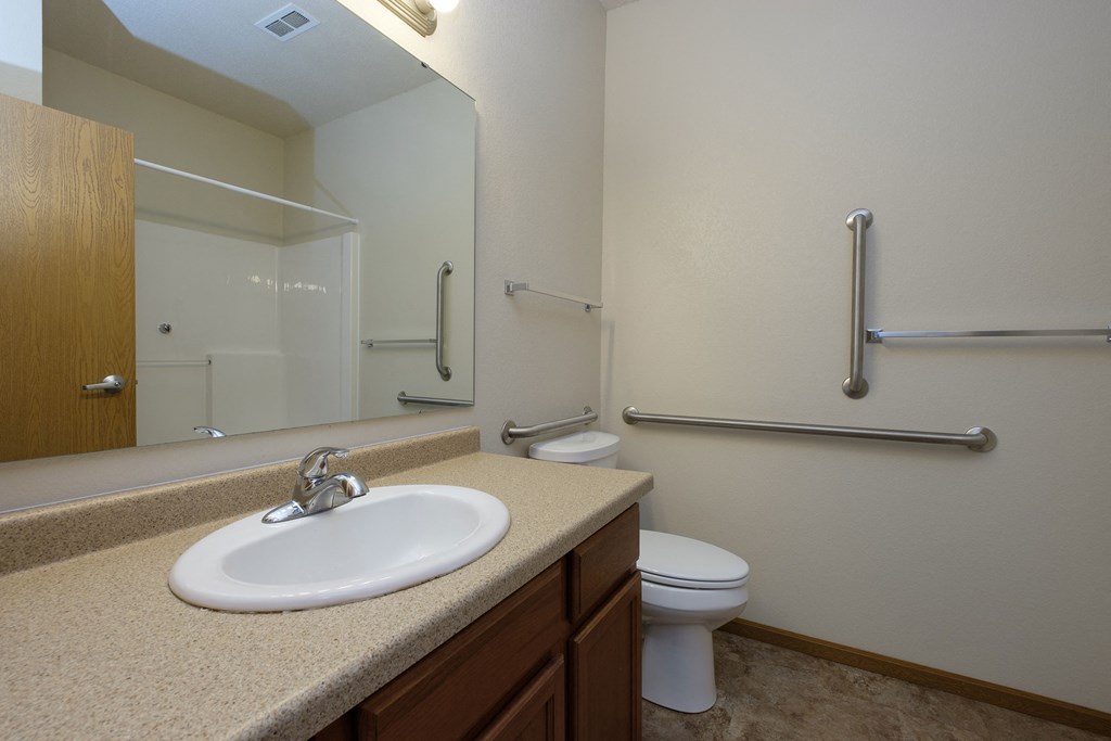a bathroom with sink toilet and mirror. Fargo, ND North Sky Apartments