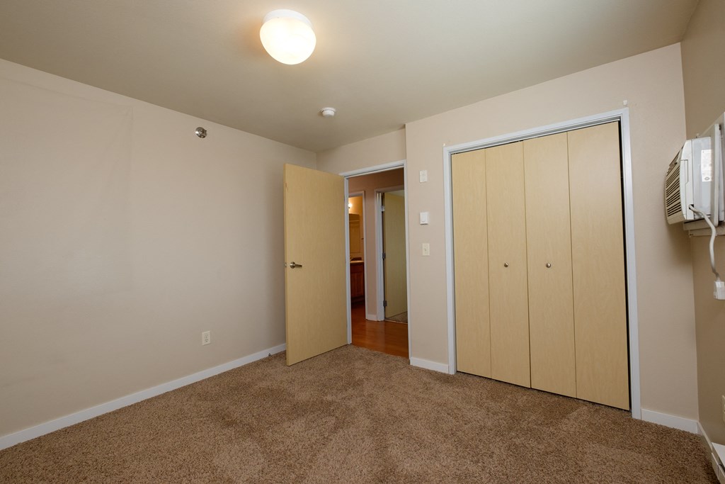 a bedroom with a closet and a door to the bathroom. Fargo, ND Thunder Creek Apartments