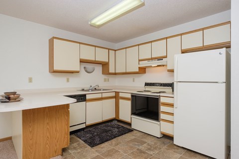 a kitchen with black and white appliances. Fargo, ND Twin Parks Apartments.