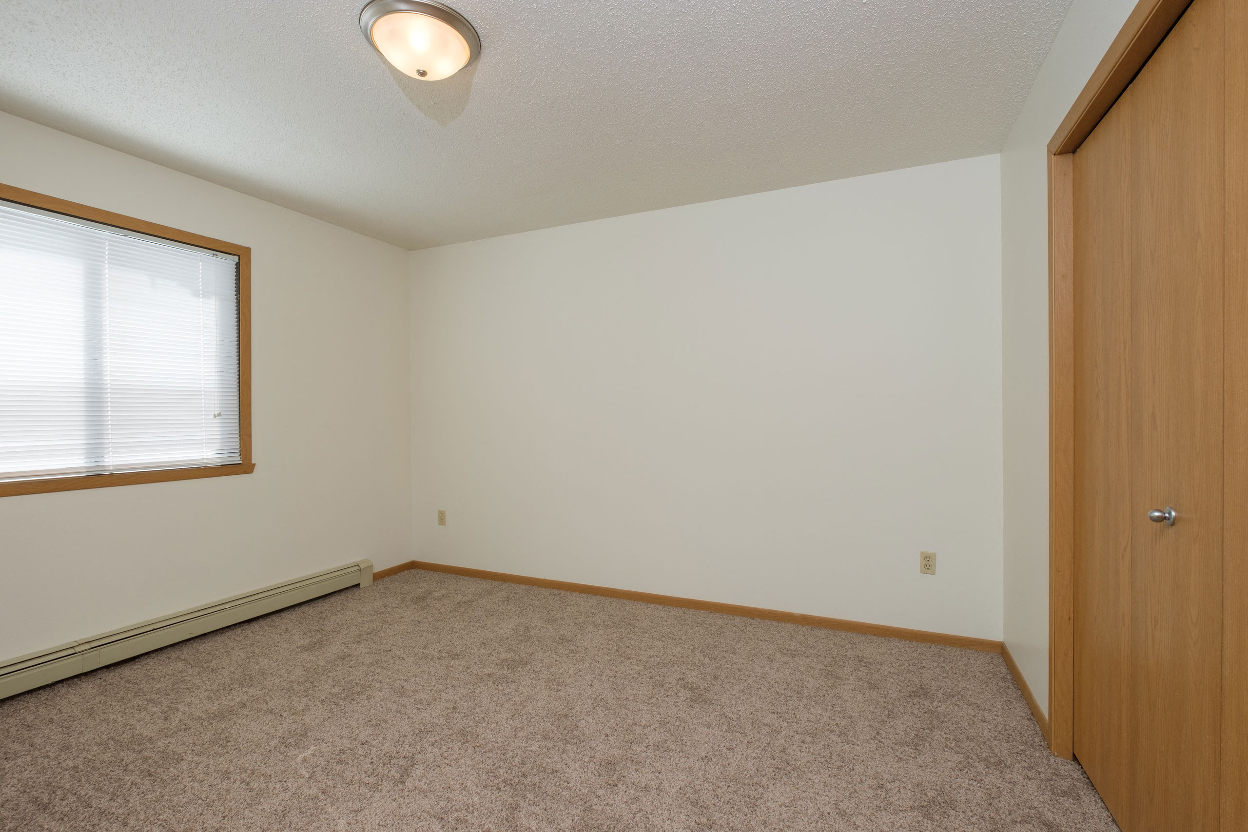 a bedroom with a window. Fargo, ND Twin Parks Apartments.