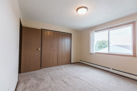 Grand Forks, ND Twin Drive Apartments. A bedroom with carpet and a window