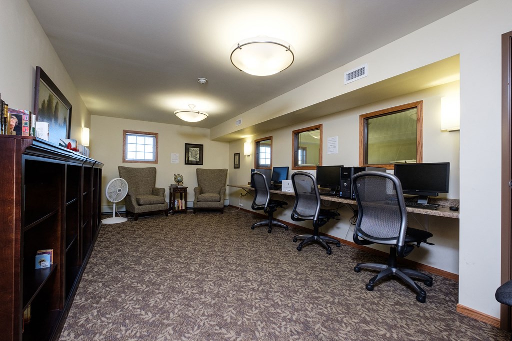 a library with computers and chairs. Fargo, ND Crossroads Apartments