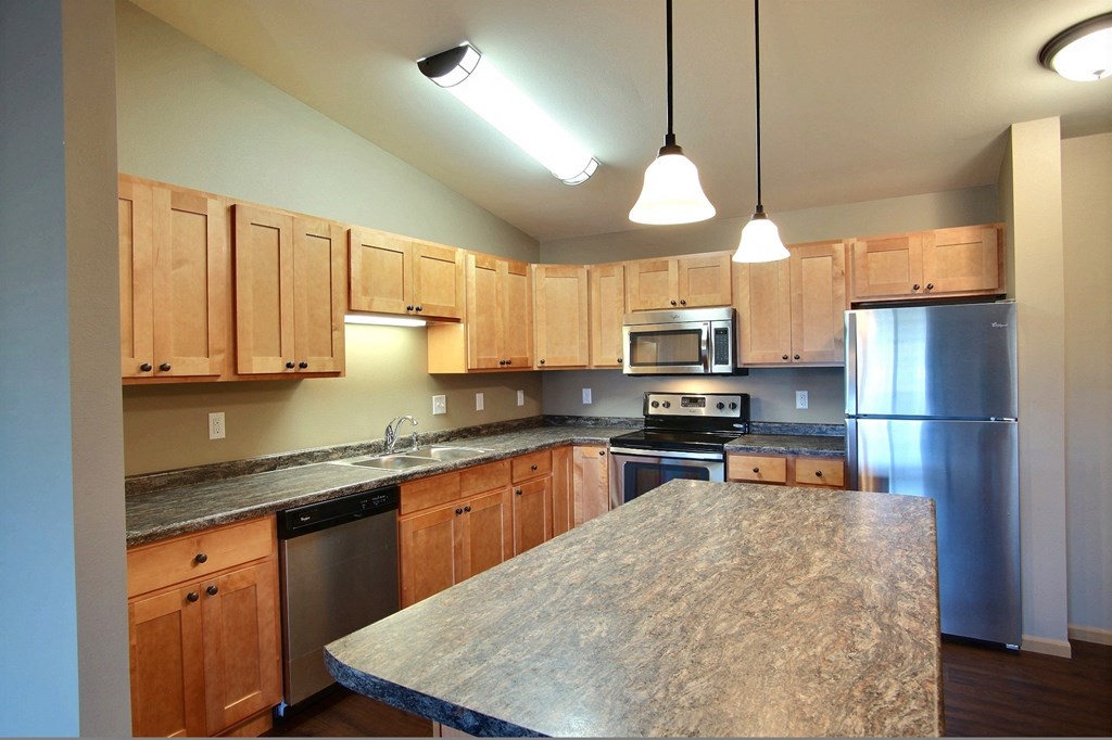 a kitchen with stainless steel appliances and granite counter tops. Fargo, ND Urban Plains Apartments