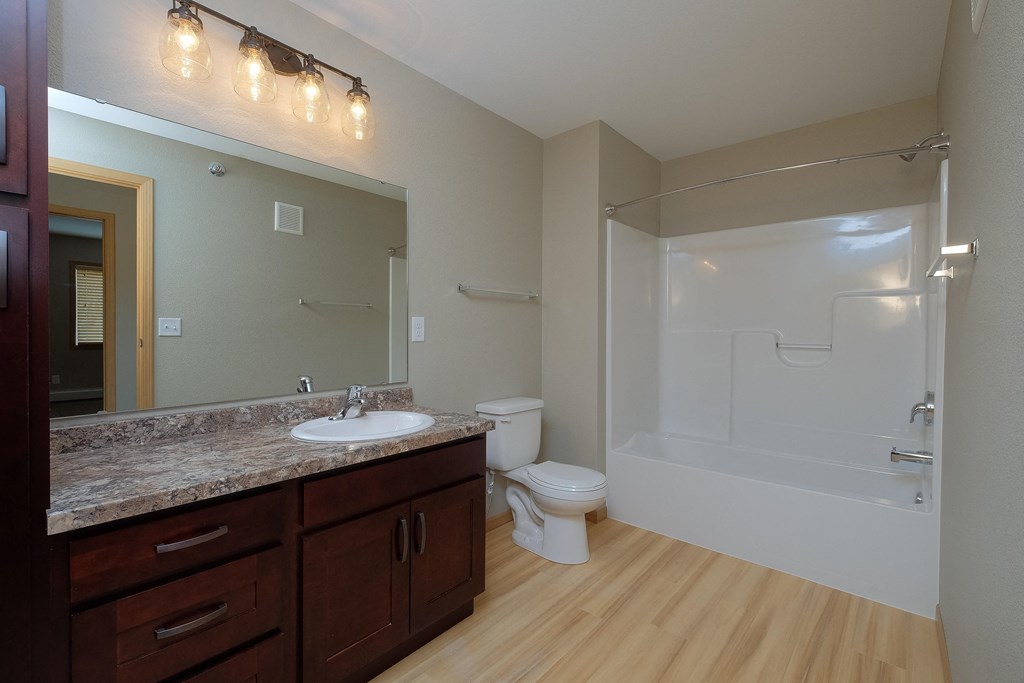 a bathroom with a sink and a toilet and a shower. Fargo, ND Urban Plains Apartments