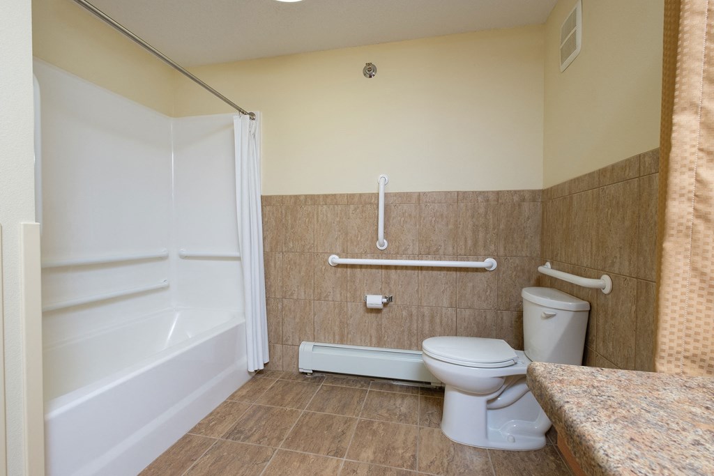 a bathroom with a toilet sink and mirror. Fargo, ND Crossroads Apartments