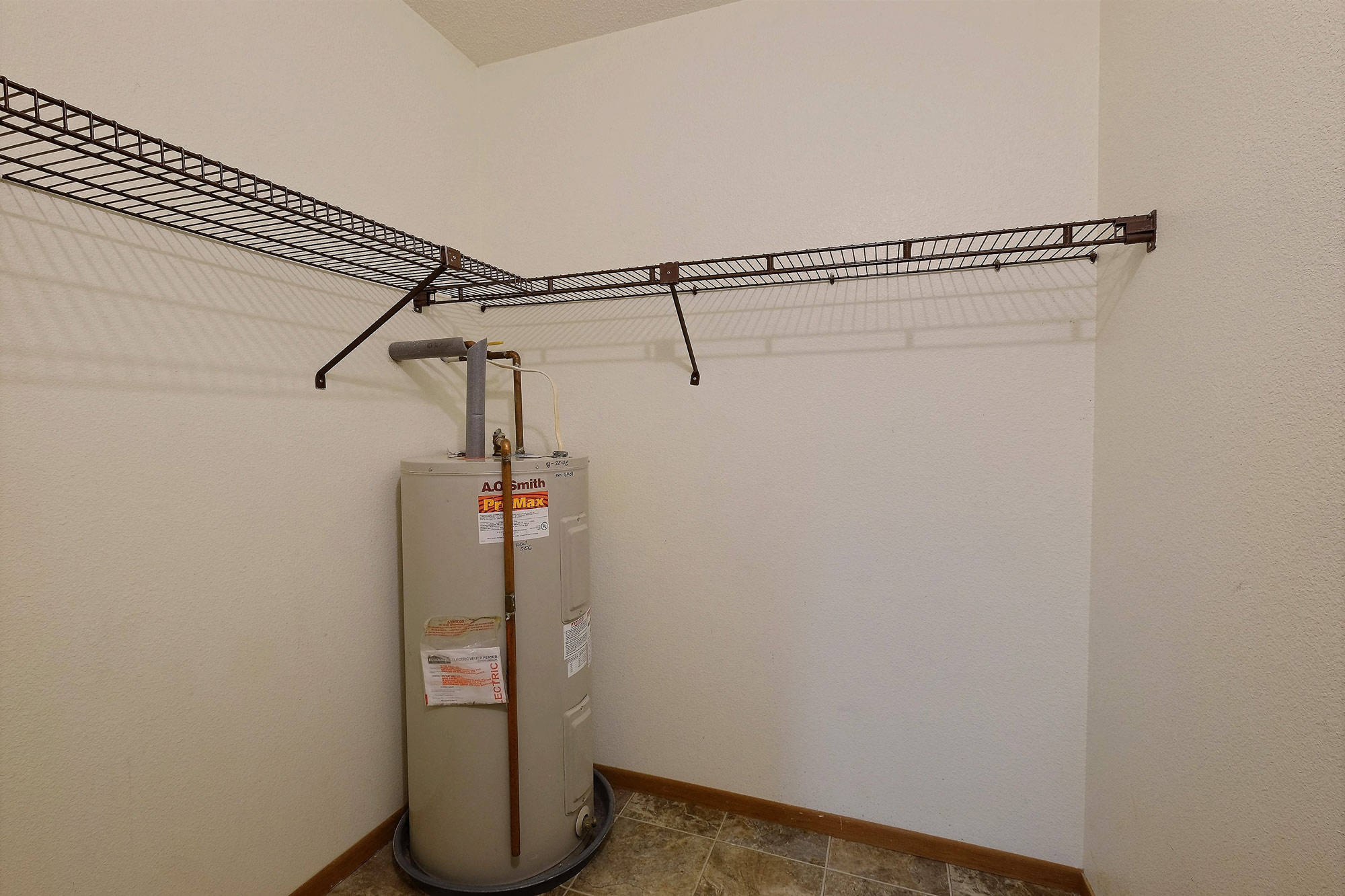 a closet with a shelf and a water heater Fargo, ND Village West Apartments