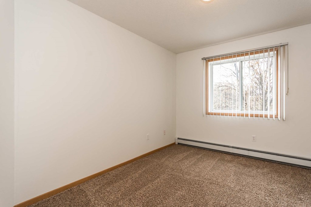 Grand Forks, ND Vista Apartments. a bedroom with white walls and a large window