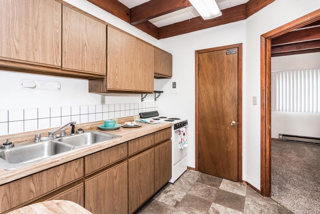 Grand Forks, ND Washington Apartments. A kitchen with a stove and a closet