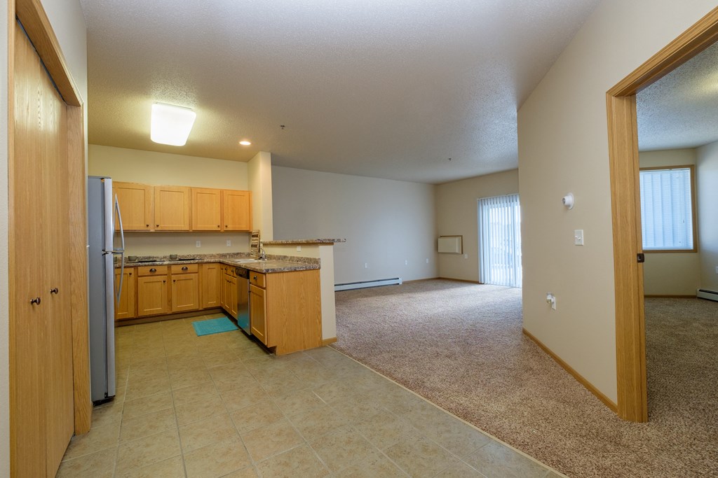 the kitchen and living room of an empty house