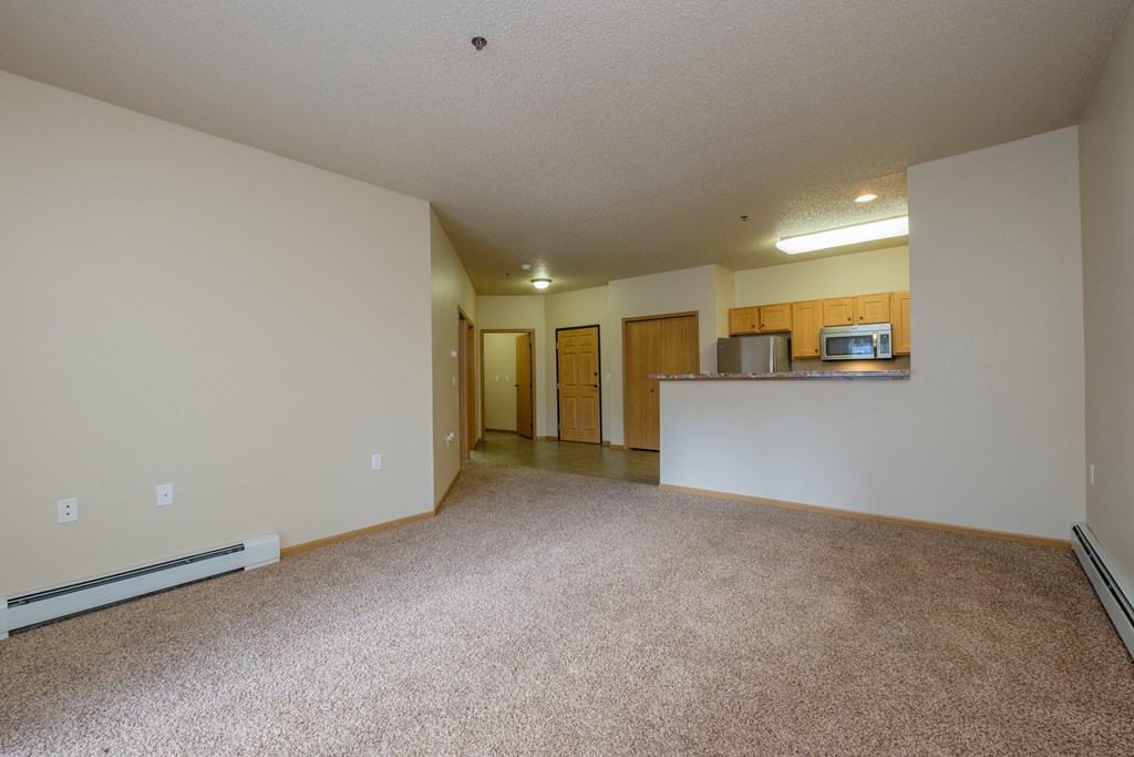 A spacious living room and kitchen of an empty apartment
