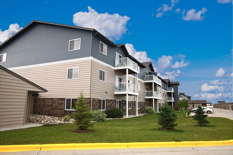 our apartments are located on the corner of a street with grass