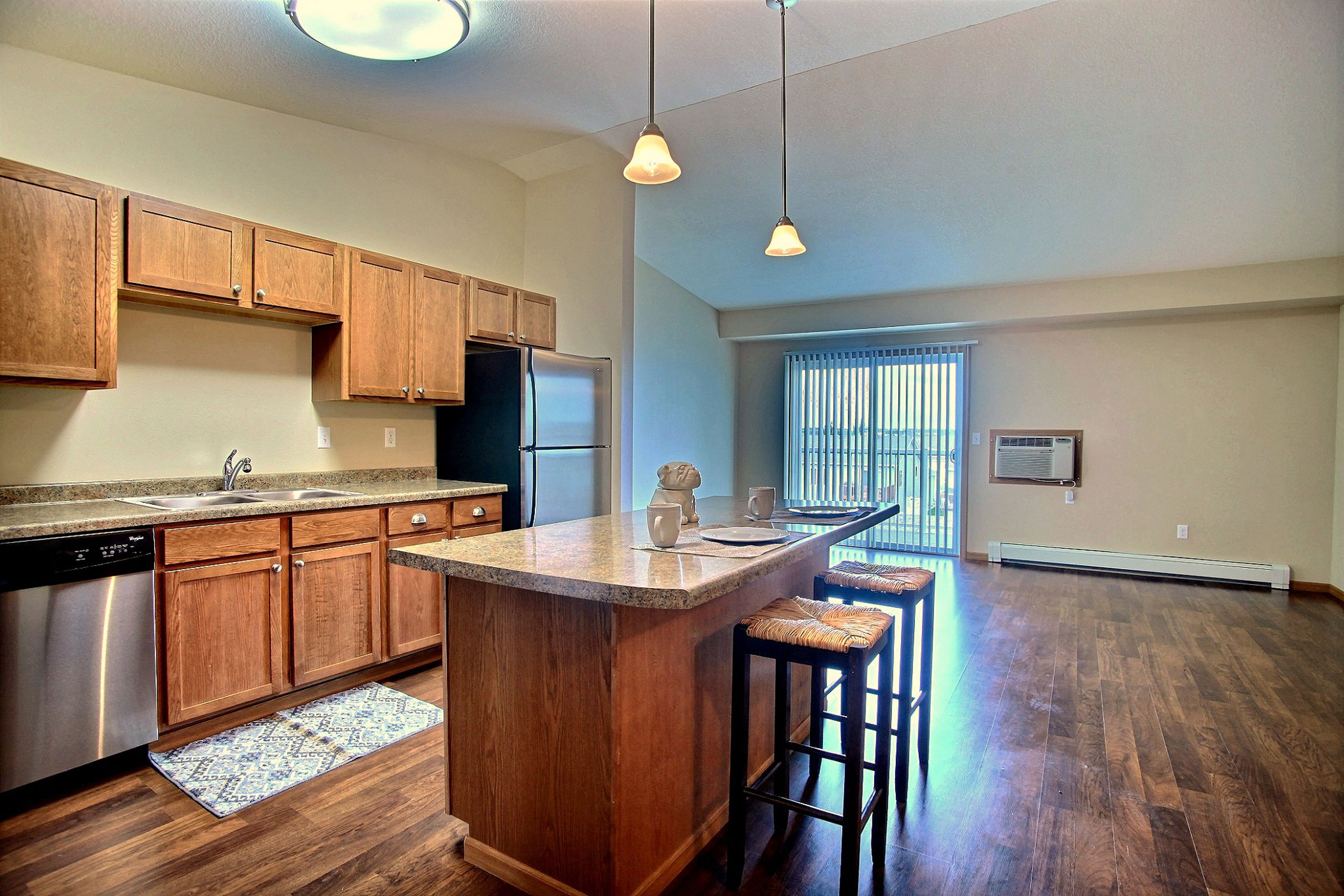 a kitchen with stainless steel appliances and wooden cabinets. Fargo, ND Wolf Creek Apartments