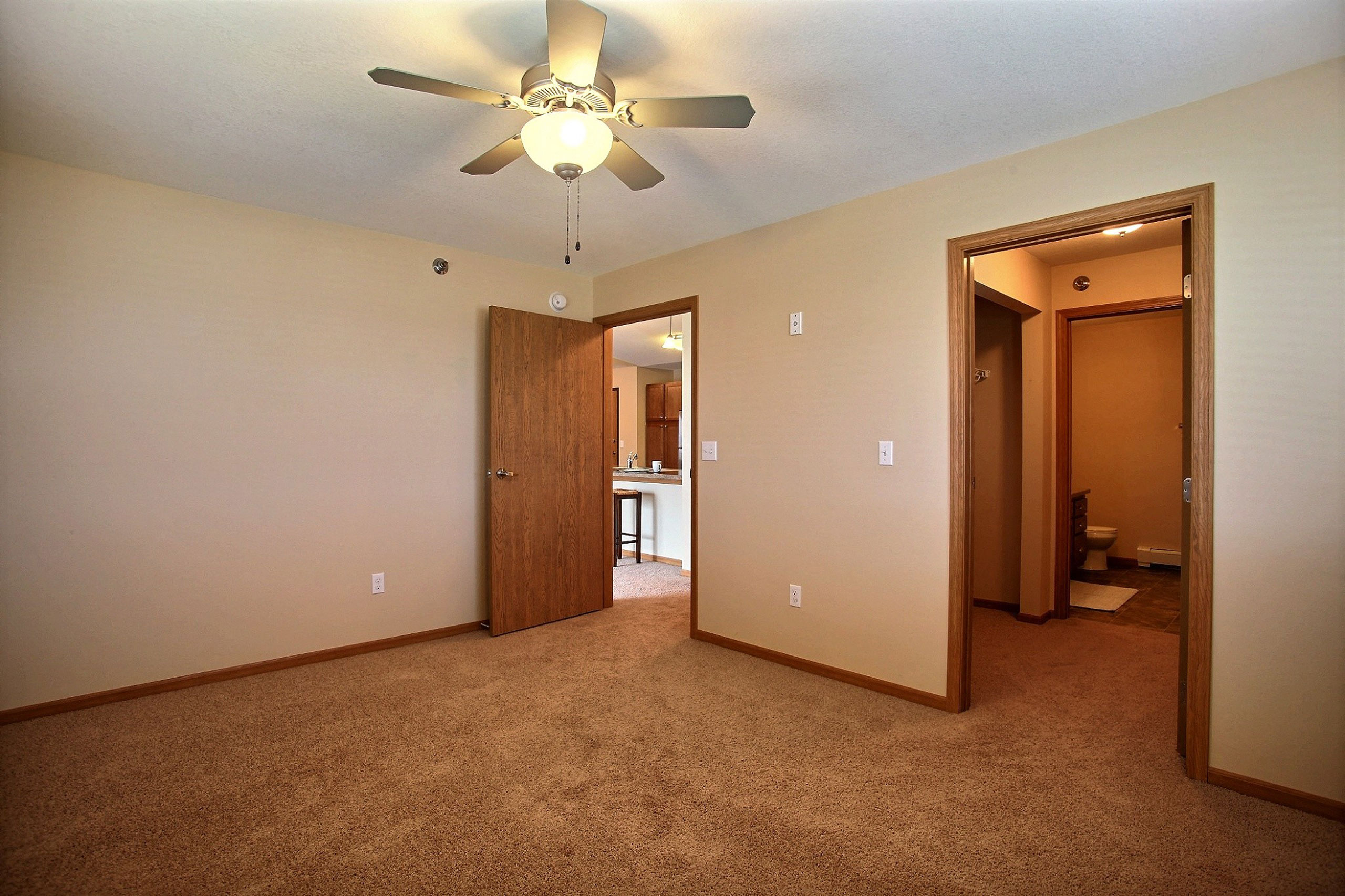 a bedroom with a closet and a door to a bathroom. Fargo, ND Wolf Creek Apartments