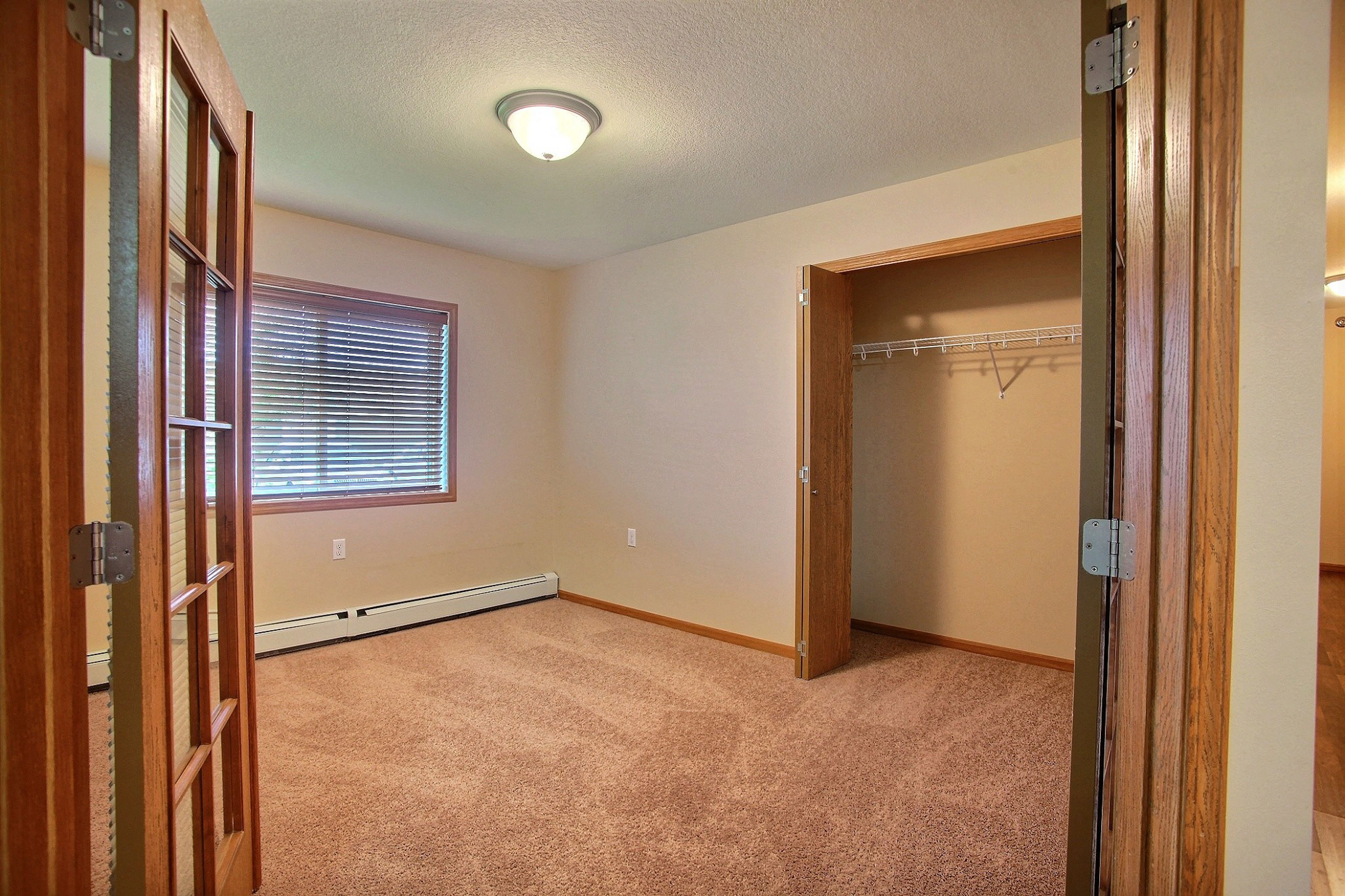 a bedroom with a closet and window. Fargo, ND Wolf Creek Apartments