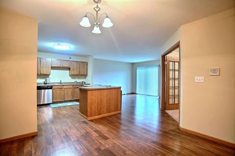 a kitchen and dining room with wood floors. Fargo, ND Wolf Creek Apartments