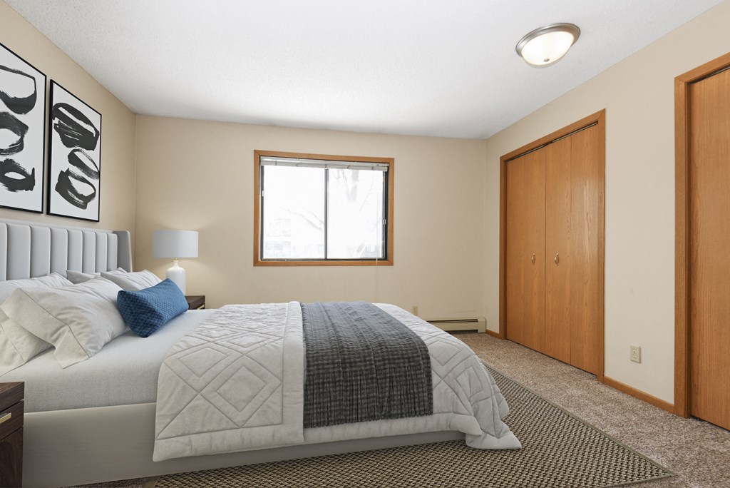 a bedroom with a bed and a window. Anoka, MN Dellwood Estates
