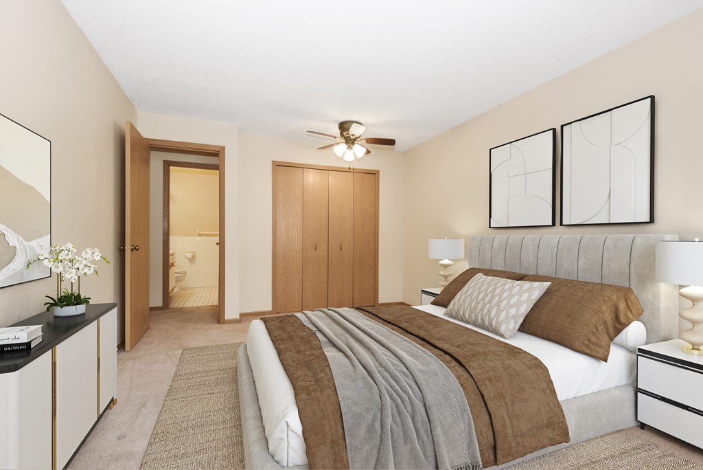 a bedroom with a large bed and a ceiling fan. Anoka, MN Dellwood Estates