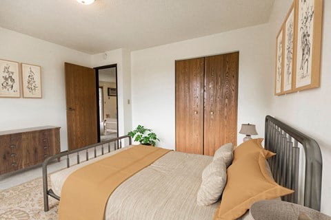 Bismarck, ND Eagle Sky I. A bedroom with a bed and a wardrobe. The yellow accents on the bed make for a bright energetic room.