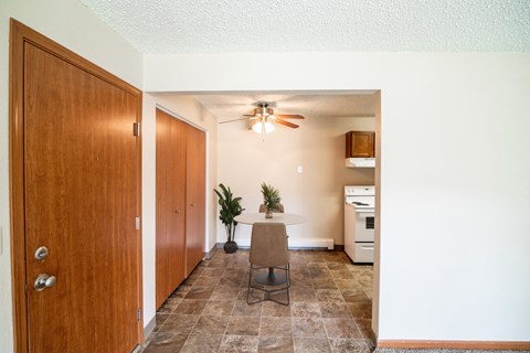 A dining room with a table and a ceiling fan. Bismarck, ND Eastbrook Apartments.