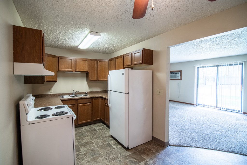 Bismarck, ND Eastbrook Apartments | a kitchen with white appliances and brown cabinets
