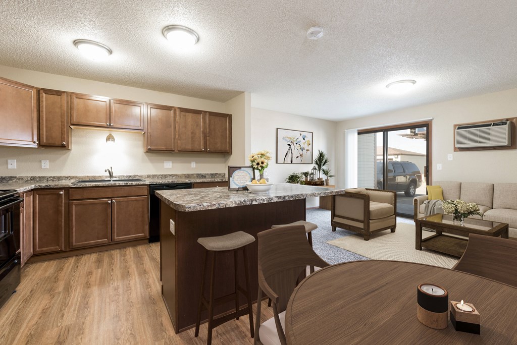 Bismarck, ND Fairview a combined dining and living area with dark wood cabinets and furnishings. The space features a dining table, chairs, and comfortable seating for the living room. It offers a versatile and inviting area for dining, relaxation, and socializing with family and friends