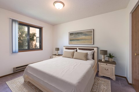 Mandan, ND Garden Grove Apartments. A bedroom with a bed and two night stands