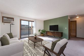 Mandan, ND Garden Grove Apartments. A living room with green walls and a sliding glass door to a balcony