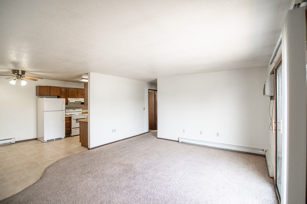 Bismarck, ND Rosser Apartments. an empty living room with a kitchen in the background