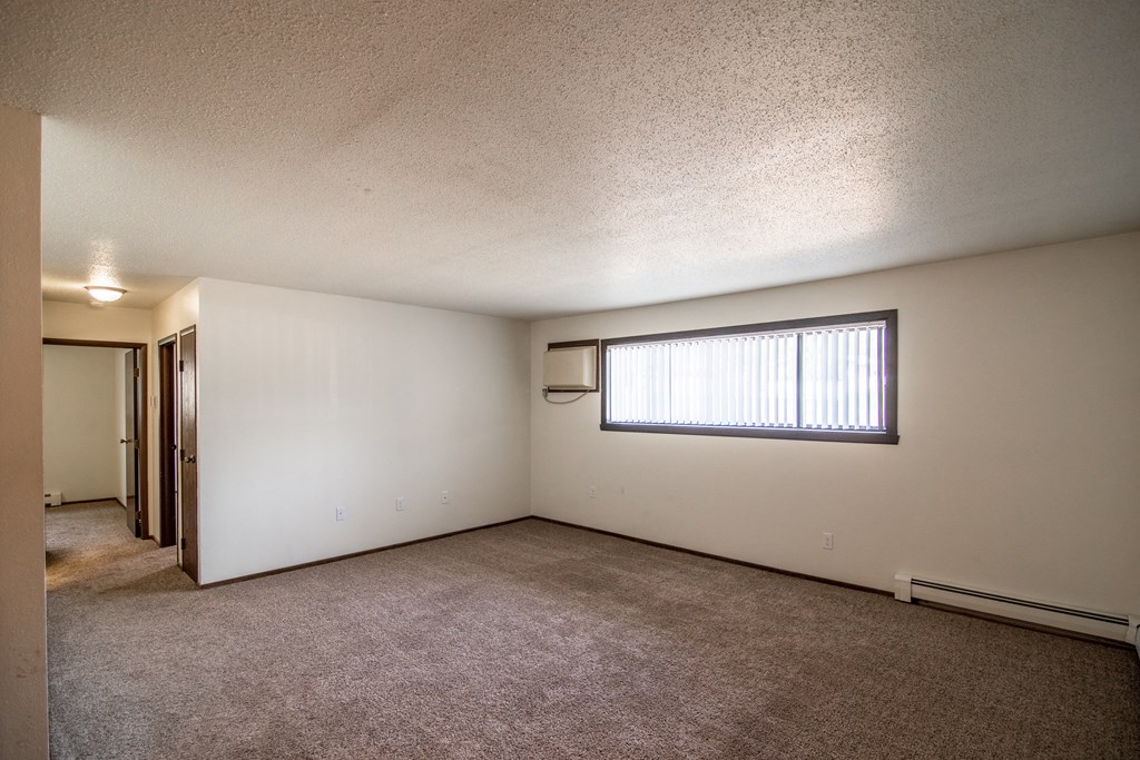 Bismarck, ND Rosser Apartments. an empty living room with a large window