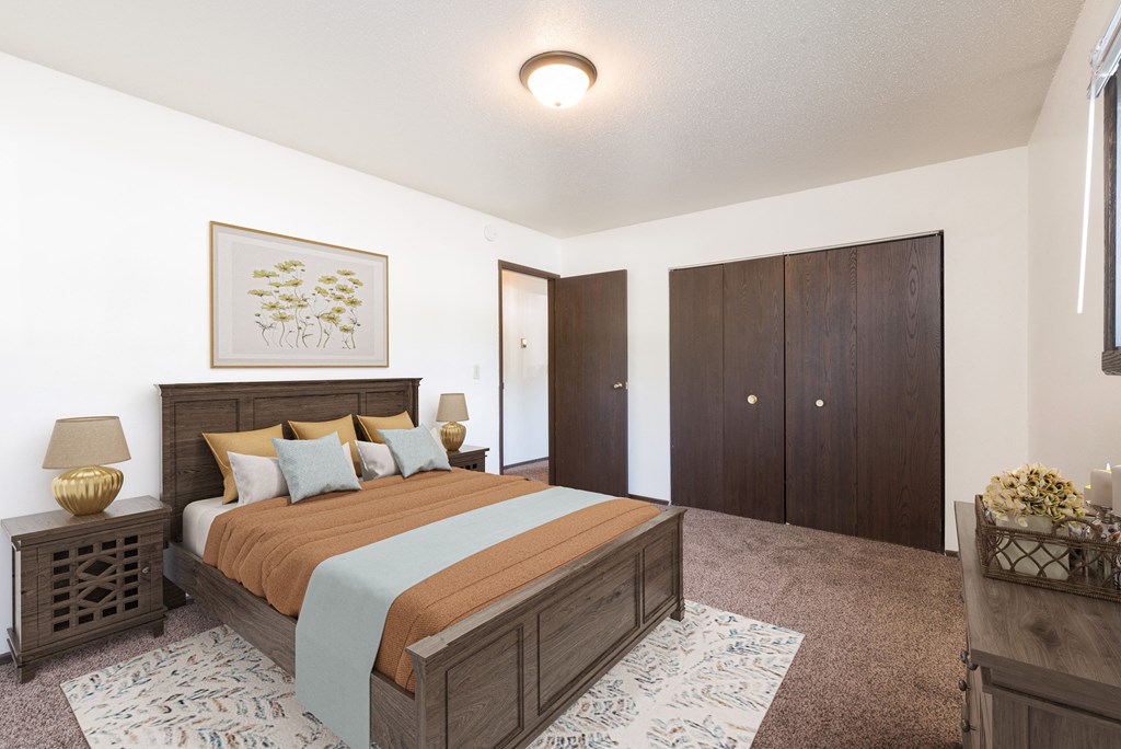Bismarck, ND Rosser Apartments. A bedroom with a large bed and a closet.