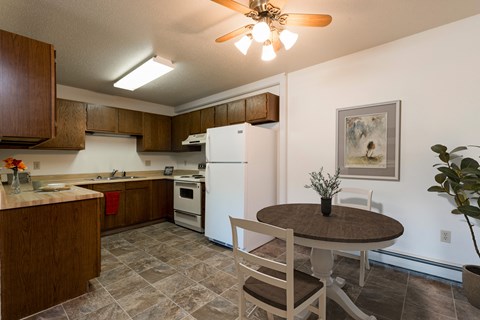 a kitchen and dining area with a table and chairs and a refrigerator